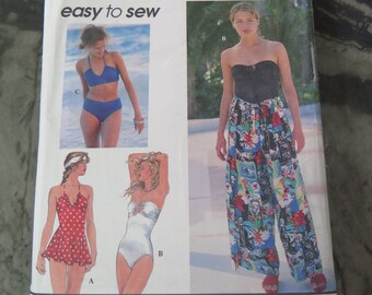 May include: Simplicity sewing pattern number 9085 for sizes 12, 14, and 16. The pattern includes instructions for making four different styles of swimwear: a red polka dot swimsuit with a halter top, a white swimsuit with a halter top, a blue bikini with a halter top, and a pair of black and white patterned pants with a strapless top.