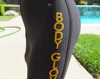 May include: Black shorts with a gold "BODY GLOVE" logo on the side.