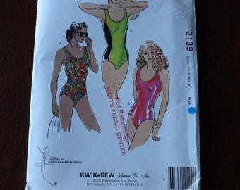 May include: A vintage Kwik Sew sewing pattern, pattern number 2139, featuring illustrations of swimsuits. The pattern includes sizes XS to XL. The cover has illustrations of women wearing swimsuits in various styles and colors.