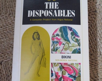 May include: A package for The Disposables Bikini, a non-woven material product. The package features a woman in a bikini and a close-up of the fabric. The text on the package reads "The Disposables, A Consumer Product from Argus National, Bikini, Non-Woven Material, Press with cool iron/Shorten with scissors/Fire-resistant unless washed or dry cleaned."