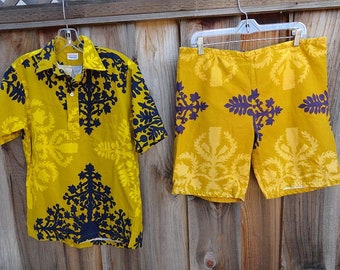 May include: A yellow and blue patterned shirt and matching shorts. The shirt has a collar and short sleeves. The shorts have a waistband and are knee-length.