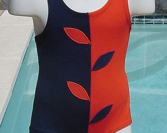 May include: A black and orange swimsuit with a leaf design. The swimsuit has a scoop neck and a racerback style.