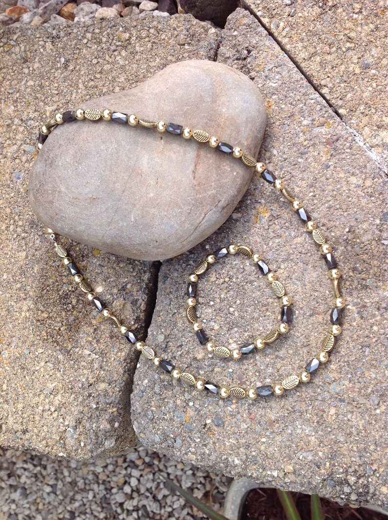 Magnetic Hematite Tube Bead Necklace with Deep Gold Leaf Embossed Accents and Gold Metal Beads