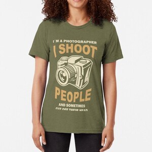 Puede incluir: Una camiseta verde con un gráfico de cámara de estilo vintage y el texto "Soy fotógrafo, fotografío personas y a veces les corto la cabeza".
