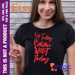 Puede incluir: Una camiseta negra con un gráfico rojo que dice "Not Today Satan Not Today" con un símbolo de pentagrama.