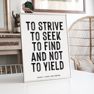 Puede incluir: Un cartel enmarcado con la cita "TO STRIVE TO SEEK TO FIND AND NOT TO YIELD" en letras negras sobre un fondo blanquecino. La cita se atribuye a Ulysses, Alfred, Lord Tennyson. El marco es plateado.