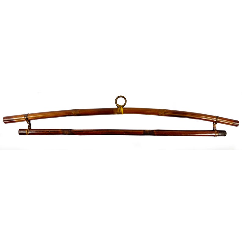 May include: A brown bamboo hanger with a metal ring at the top and a second bar for hanging clothes.