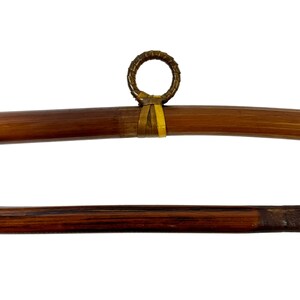 May include: Two brown bamboo rods with a woven ring at the end of one rod. The rods are approximately 30 inches long.