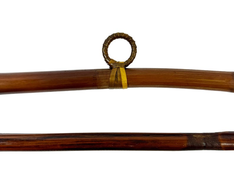 May include: Two brown bamboo rods with a woven ring at the end of one rod. The rods are approximately 30 inches long.