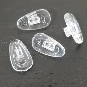 May include: Four clear plastic replacement earbud tips for eyeglasses. The tips are designed to fit over the earpiece of eyeglasses.