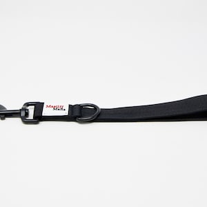 May include: Black dog leash with a black swivel hook and a D-ring. The leash has a loop handle and a white tag with the text "Mastiff Mafia" in red and black.
