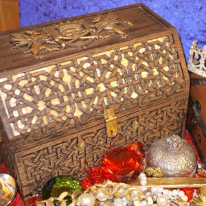 May include: A wooden treasure chest with intricate carvings and a brass lock. The chest is open and filled with gold coins, jewels, and other treasures.