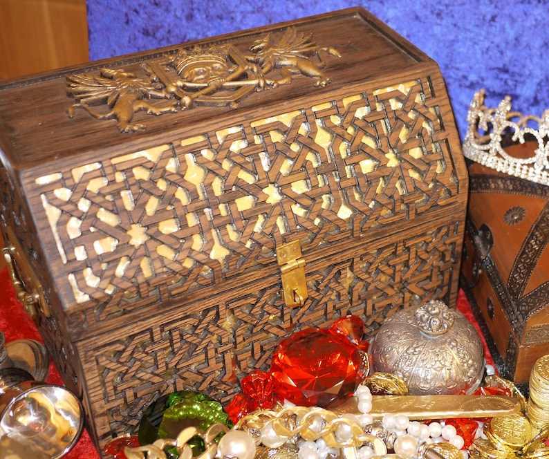 May include: A wooden treasure chest with intricate carvings and a brass lock. The chest is open and filled with gold coins, jewels, and other treasures.
