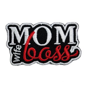 Pode incluir: Patch bordado branco e vermelho com o texto "MOM" em branco e "Wife Boss" em vermelho.