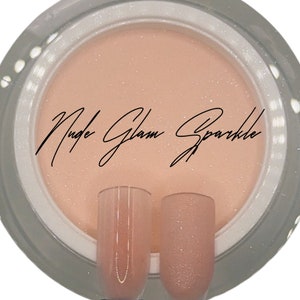 Puede incluir: Un tarro de esmalte de u&ntilde;as de brillo nude con el texto "Nude Glam Sparkle" en la etiqueta. Se muestran dos puntas de u&ntilde;as transparentes con el esmalte de brillo aplicado.