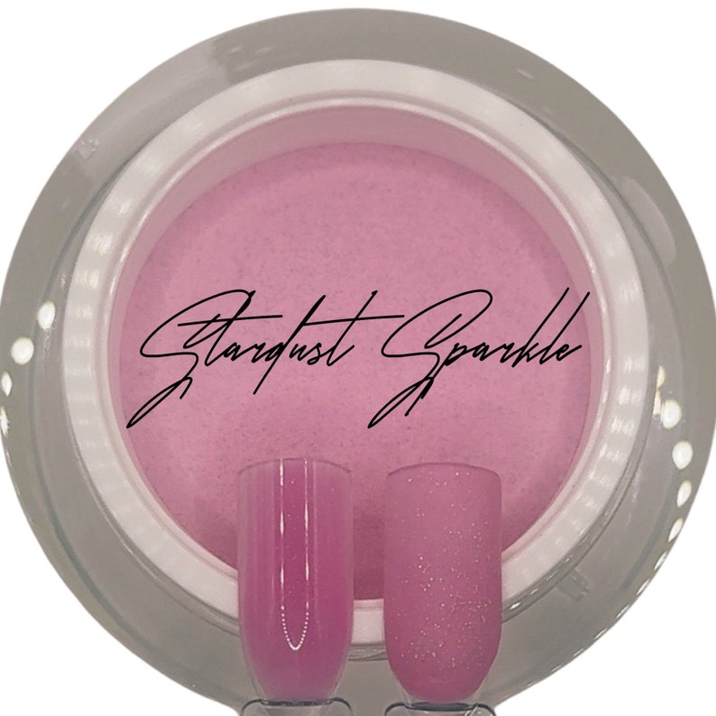 Puede incluir: Un tarro de polvo de u&ntilde;as de brillo rosa con el texto "Stardust Sparkle" en la etiqueta. Dos peque&ntilde;os frascos de vidrio muestran el brillo en diferentes iluminaciones.