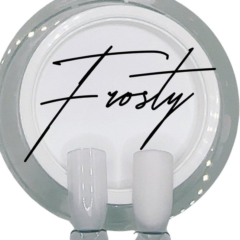 Puede incluir: Dos botellas de esmalte de u&ntilde;as de vidrio transparente con un esmalte blanco opaco en su interior. Las botellas est&aacute;n sobre una superficie blanca con la palabra "Frosty" escrita en cursiva negra.
