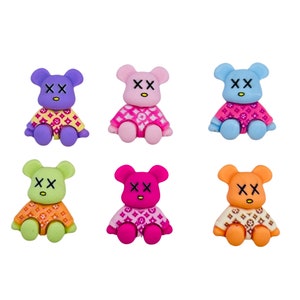 May include: Six small plush teddy bears with a pink, blue, purple, green, orange, and magenta color scheme. Each bear is wearing a pink and white patterned shirt with the letters "XX" on the chest.