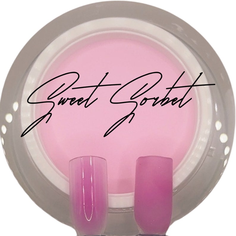 Puede incluir: Un polvo de inmersi&oacute;n para u&ntilde;as de color rosa en un frasco transparente con tapa blanca. El frasco tiene una etiqueta negra con el texto "Sweet Sorbet". Se muestran dos puntas de u&ntilde;as, una con un efecto degradado rosa y la otra con un color rosa s&oacute;lido.