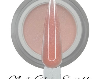 Könnte beinhalten: Ein Glas mit nude-rosa Glitzer-Dip-Pulver für Nägel, in das ein durchsichtiger Nageltupfer getaucht ist. Das Glas hat einen silbernen Deckel und der Text "Nude Glam Sparkle" ist unter dem Glas geschrieben.