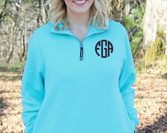 May include: A turquoise blue quarter-zip pullover sweatshirt with a black monogram of the letters "EGA" on the front.