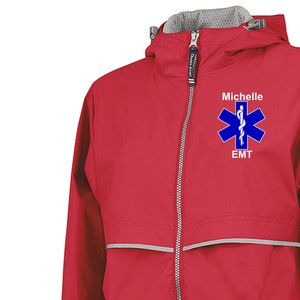 May include: Red raincoat with a reflective strip and a zip closure. The jacket has a hood and a patch with a blue star of life and the text "Michelle EMT".