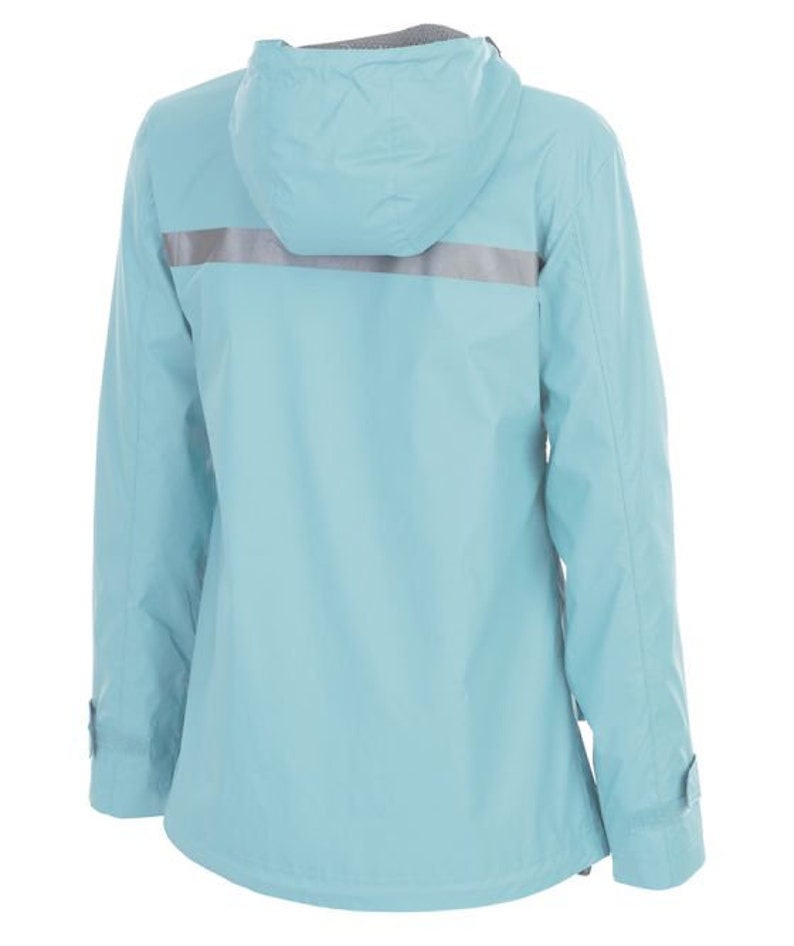 May include: A light blue hooded rain jacket featuring a horizontal reflective silver stripe across the back and shoulders. The jacket has long sleeves with adjustable cuffs, a hood, and a smooth, water-resistant finish on the exterior fabric.
