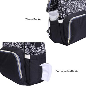 May include: A black and gray leopard print diaper bag with multiple pockets. The bag has a large pocket on the front labeled "Bottle, umbrella etc" and a smaller pocket on the top labeled "Tissue Pocket".