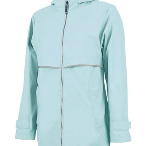 May include: A light blue hooded rain jacket featuring a full-length silver zipper, a grey mesh-lined interior, and a horizontal reflective strip across the chest. The jacket includes adjustable cuffs with straps and a drawstring hood closure.