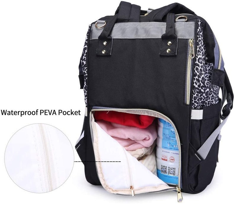 May include: A black and grey backpack with a leopard print detail. The backpack has a large zippered pocket on the front and a smaller zippered pocket on the side. The backpack is open and you can see the inside of the bag, which is lined with a white fabric. The backpack has a waterproof PEVA pocket.