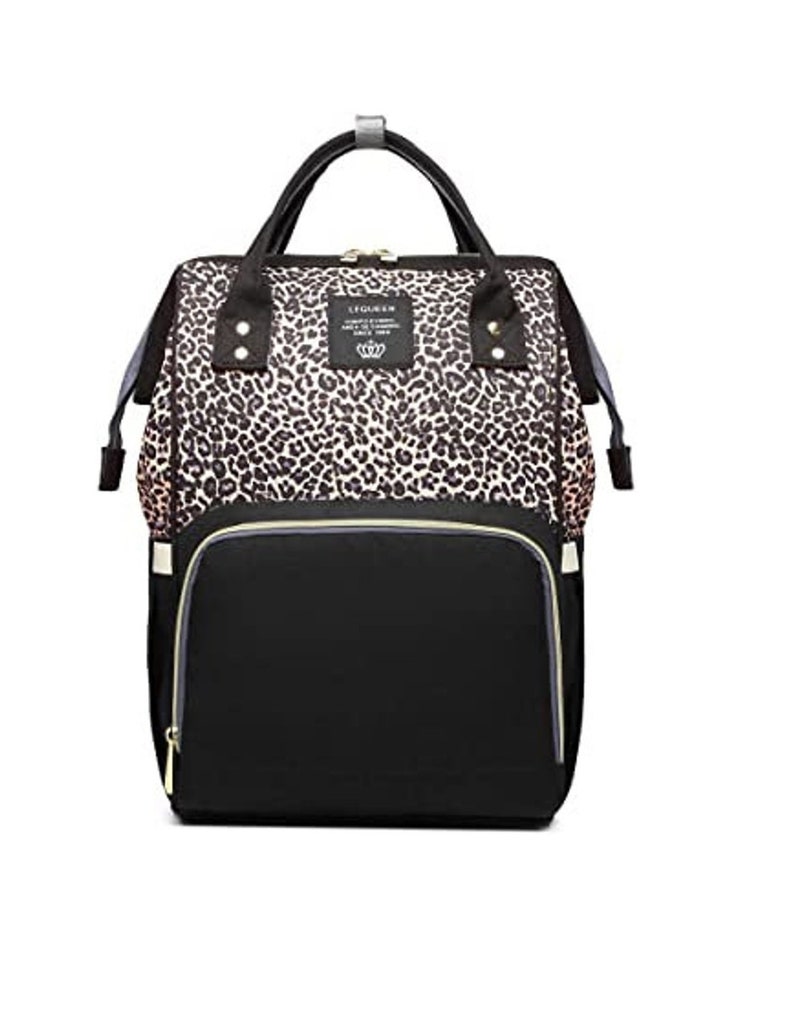 May include: A black and brown leopard print diaper bag with a black zipper and a black front pocket. The bag has a gold zipper pull and a gold logo that says "LEGOUDEN".