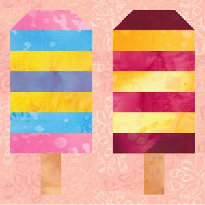 Könnte beinhalten: Zwei bunte Stoff-Patches in Form von Eis am Stiel mit einem gestreiften Design. Das Eis am Stiel links ist rosa, blau, gelb und lila. Das Eis am Stiel rechts ist rotbraun, gelb und rosa.