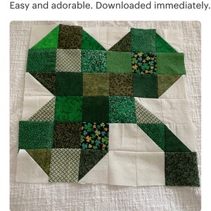 May include: A green and white patchwork quilt block with a shamrock design. The block is made up of squares and triangles of different shades of green and white fabric.
