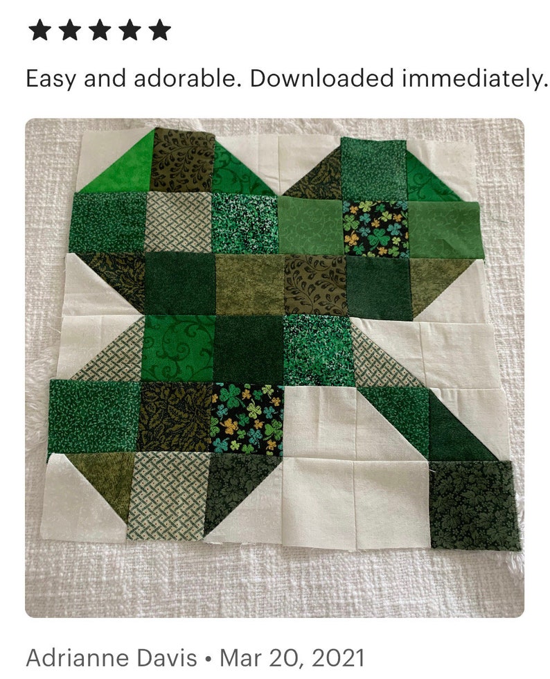 May include: A green and white patchwork quilt block with a shamrock design. The block is made up of squares and triangles of different shades of green and white fabric.