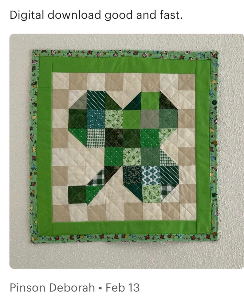 May include: A green and white patchwork quilt with a shamrock design. The quilt is framed with a green border and a white and green border. The quilt is hanging on a white wall. Pinson Deborah &bull; Feb 13
