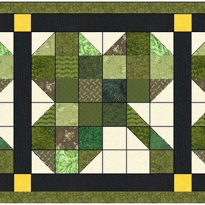 May include: A quilt runner with a repeating pattern of green and white squares, forming a star shape. The runner has a black border with yellow accents.