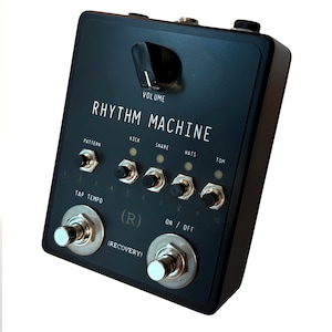 May include: Black Rhythm Machine effects pedal with white text and silver knobs. Features include volume control, tap tempo, and on/off switch. Labeled with "Kick", "Snare", "Hats", and "Tom" controls. Includes the text "Rhythm Machine".