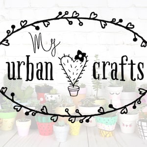 May include: A black and white illustration of a cactus with a heart shape and a flower on top. The text "My urban crafts" is written in a cursive font above the cactus. The image is surrounded by a wreath of hearts and leaves. There are many small painted flower pots in the background.