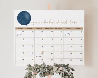 Op de afbeelding: Een kalender met de tekst "guess baby's birth date" en een marineblauwe ballongrafiek. De kalenderraster is goudkleurig, met de maanden juni en juli gemarkeerd. Een takje groen siert de onderkant.