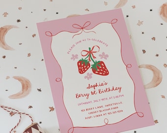 Peut inclure: Une carte d'invitation rose avec un ruban rouge et deux fraises rouges avec des feuilles vertes. Le texte sur la carte indique "Veuillez vous joindre à nous pour célébrer le 1er anniversaire de Sophia. Samedi 19 juillet à 14h00. 123 Berry Lane, Sweetville, Cherry Blossom Park. RSVP : Linda au 123.321.1234."