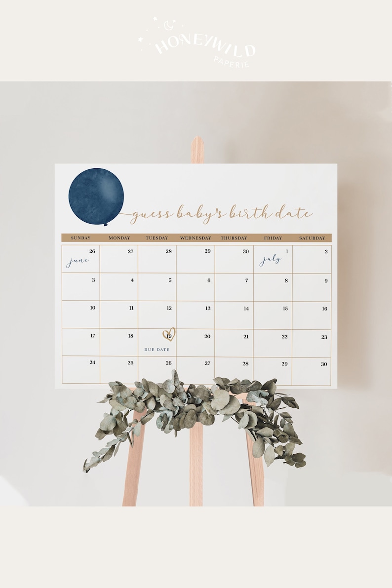 Op de afbeelding: Een kalender met de tekst "guess baby's birth date" en een marineblauwe ballongrafiek. De kalenderraster is goudkleurig, met de maanden juni en juli gemarkeerd. Een takje groen siert de onderkant.