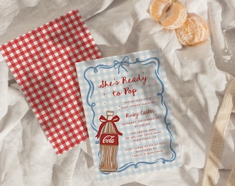Puede incluir: Una invitación para un baby shower con una ilustración de una botella de refresco vintage. La invitación presenta el texto "She's Ready to Pop" en escritura roja, con detalles del evento y un patrón de cuadros rojos y blancos.