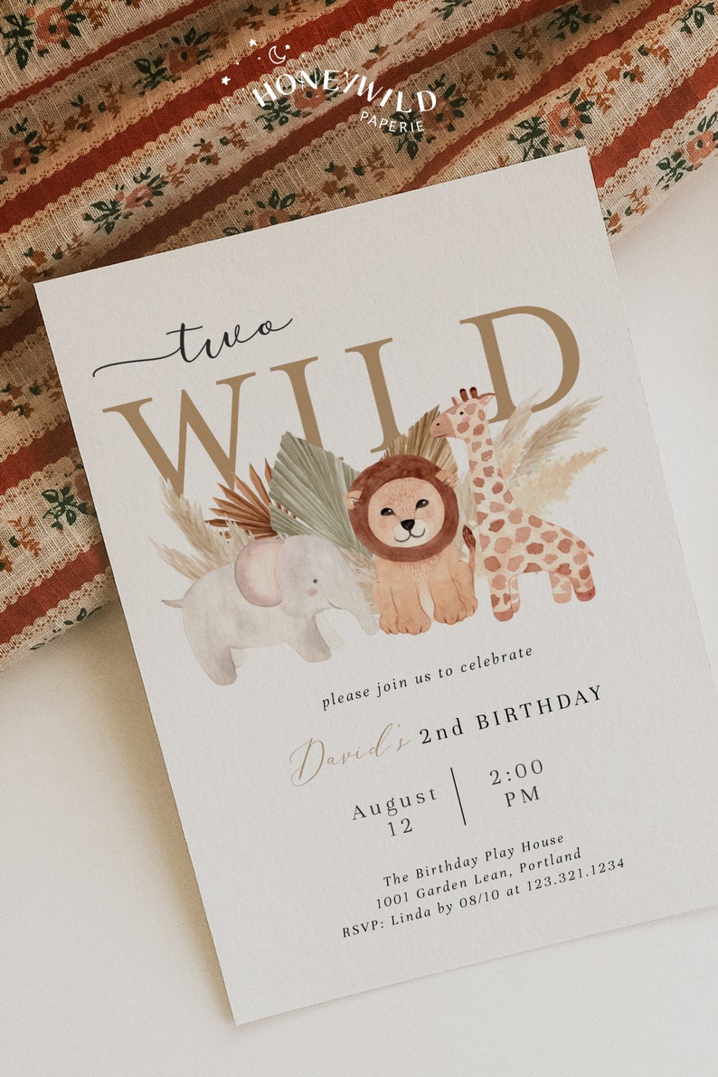 Op de afbeelding: Een beige uitnodigingskaart met een bruine en gouden tekst "two wild". De kaart heeft een aquarel-illustratie van een leeuw, een giraffe en een olifant met groene bladeren en beige gras. De tekst "David's 2nd Birthday" is in cursief geschreven met de datum en tijd eronder.