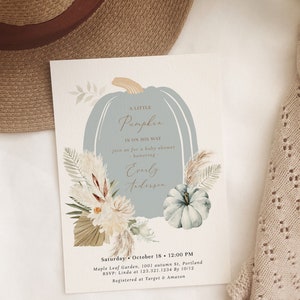 Puede incluir: Una calabaza azul claro con el texto "A Little Pumpkin Is On His Way" y "join us for a baby shower honoring Everly Anderson". La invitaci&oacute;n est&aacute; decorada con elementos florales de oto&ntilde;o y tiene el texto "Saturday, October 18, 12:00 PM, Maple Leaf Garden, 1001 autumn St, Portland, RSVP: Linda at 123.321.1234 By 10/12, Registered at Target & Amazon".