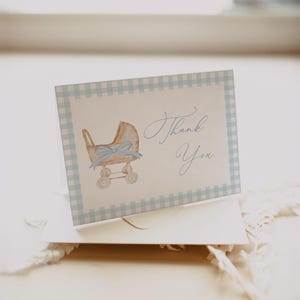 Blue gingham baby shower invitation set featuring a vintage baby carriage illustration, soft baby boy colors, and classic traditional styling. Editable baby shower bundle with coordinated invitation, books for baby card, diaper raffle ticket, and thank you card for an elegant and timeless celebration.