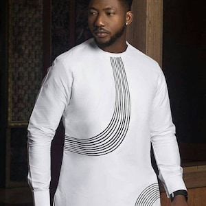 May include: A white long-sleeved shirt with a black geometric design on the front. The design features a curved line with multiple parallel lines.