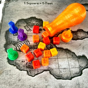 May include: A set of colorful dice with numbers 1 through 6, a small orange ceramic bottle, and a small orange ceramic flame. The dice are arranged on a gray and white gridded surface with the text "1 Square = 5 Feet".