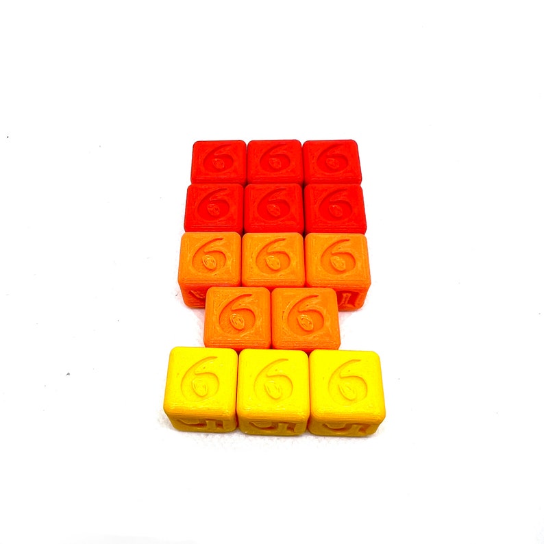 May include: A stack of 12 orange, red, and yellow cubes with the number 6 printed on each side.