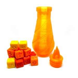 May include: A set of orange and yellow dice with numbers 1 through 6, a small orange flame-shaped object, and a tall orange glass bottle.