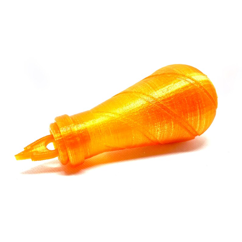 May include: A small, orange, plastic bottle with a pointed tip and a textured surface.